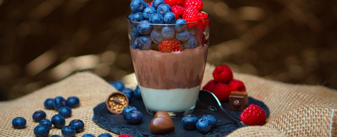 A cup of chocolate pudding with berries. chocolate pudding with berries